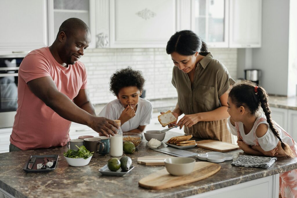 Familia en la cocina preparando una comida juntos.