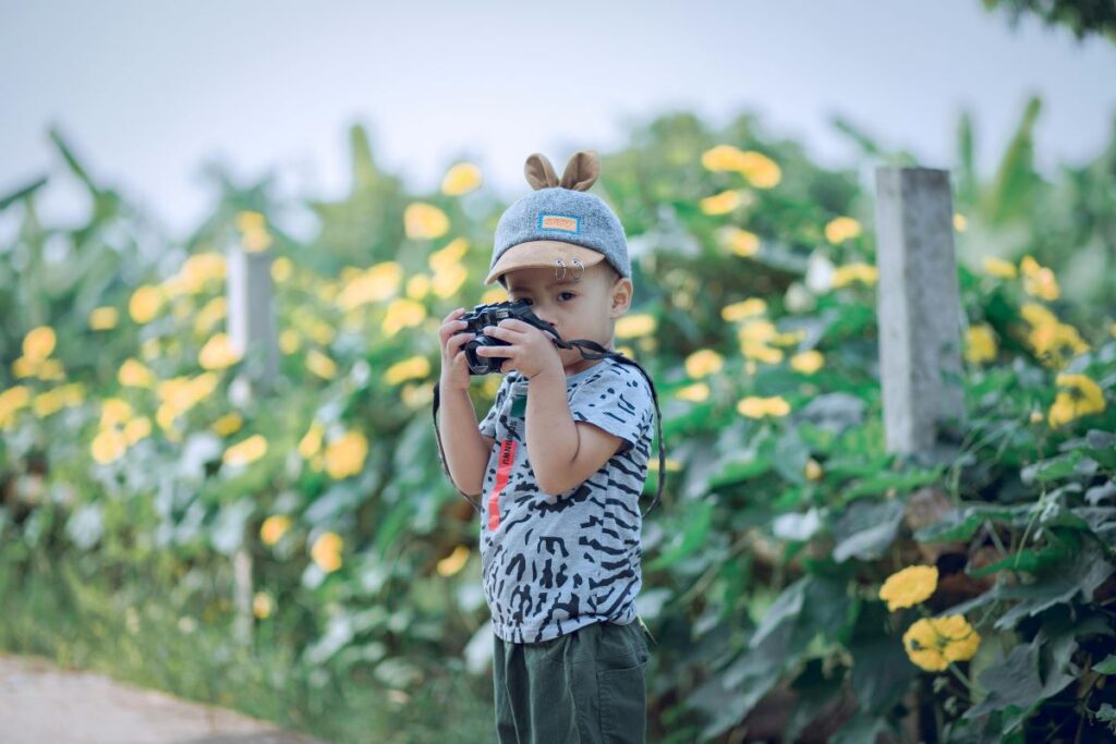 Menino em frente a flores amarelas