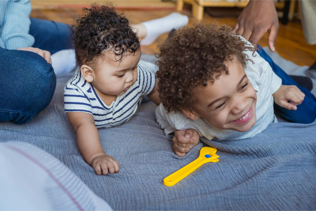 Dois jovens irmãos negros brincando em casa