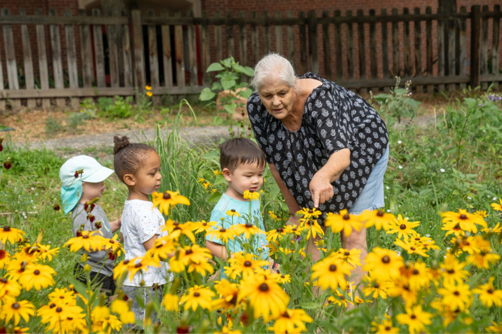 Teacher with young children and flowers