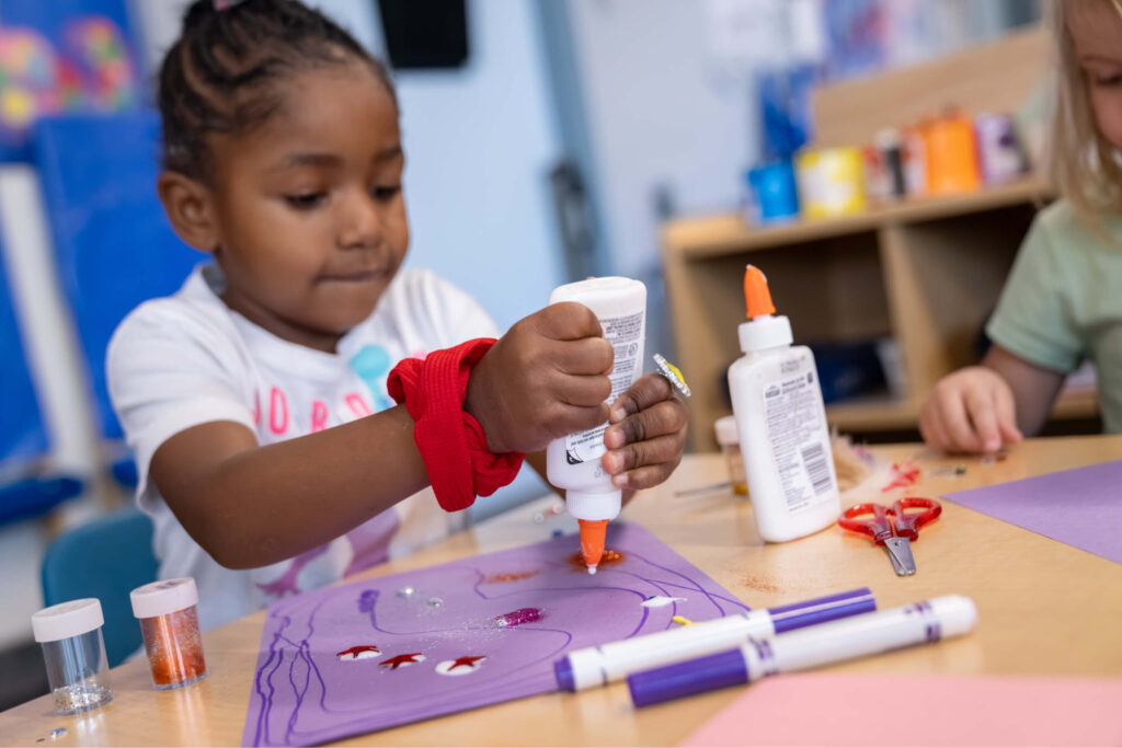 Une fillette noire d'âge préscolaire fait des travaux manuels