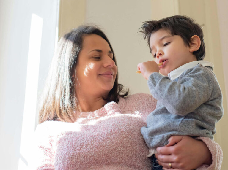 Une mère tient son fils dans ses bras tout en le regardant.