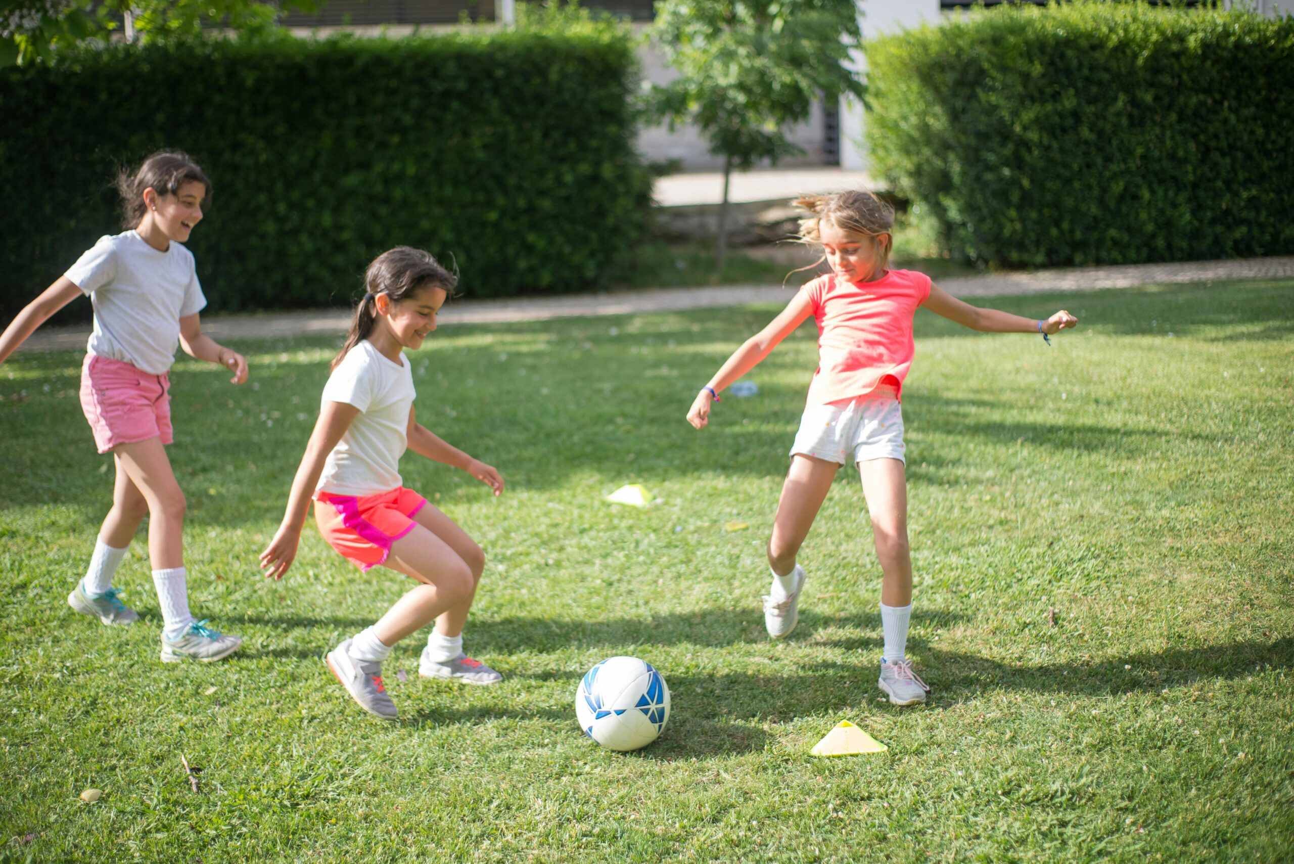 Drei junge Mädchen spielen Fußball