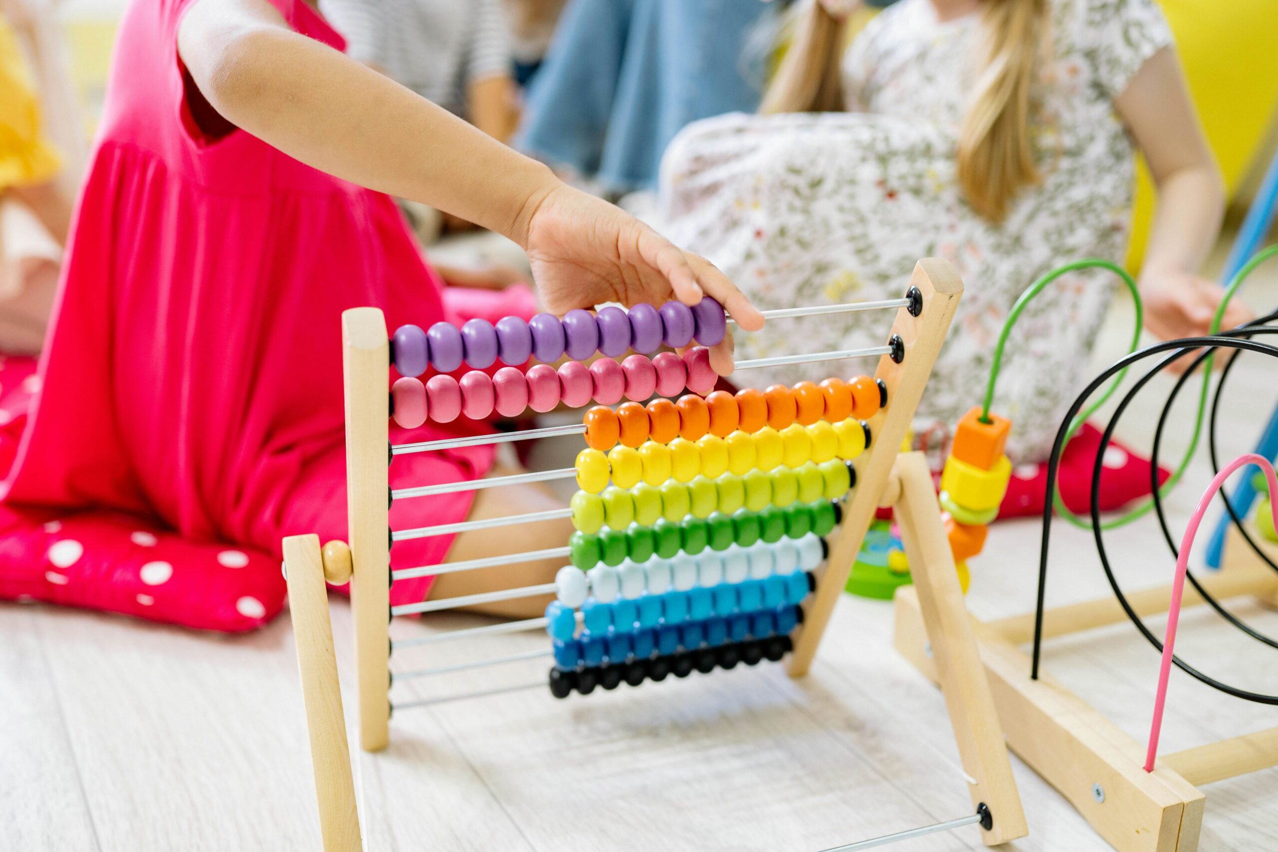 Girl in magenta dress playing with an abacus