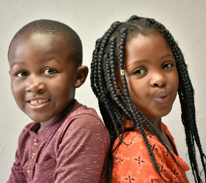 Two children sitting back to back