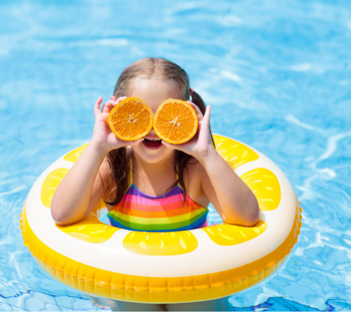 Mädchen mit Sonnenbrille sitzt in einem Schlauchboot im Wasser