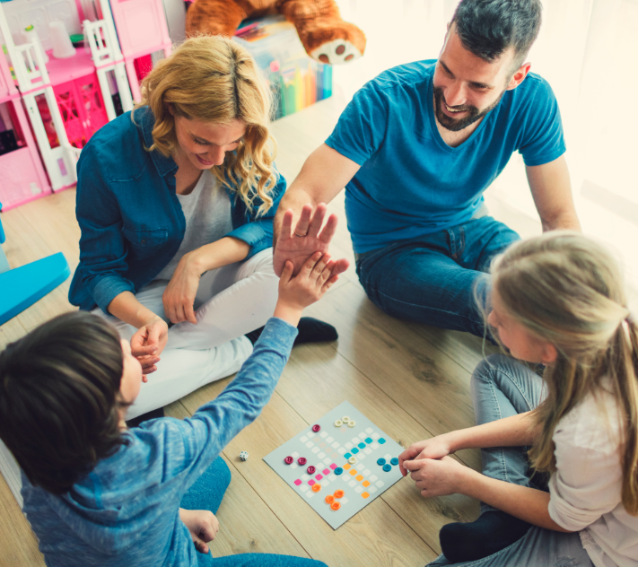 Niño, madre, padre y niña jugando un juego