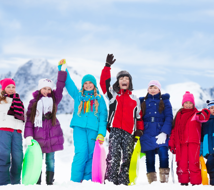 Kids in snow gear standing in a line and celebrating after a race